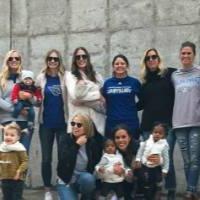 GVSU volleyball alumni and their kids pose for a photo outside